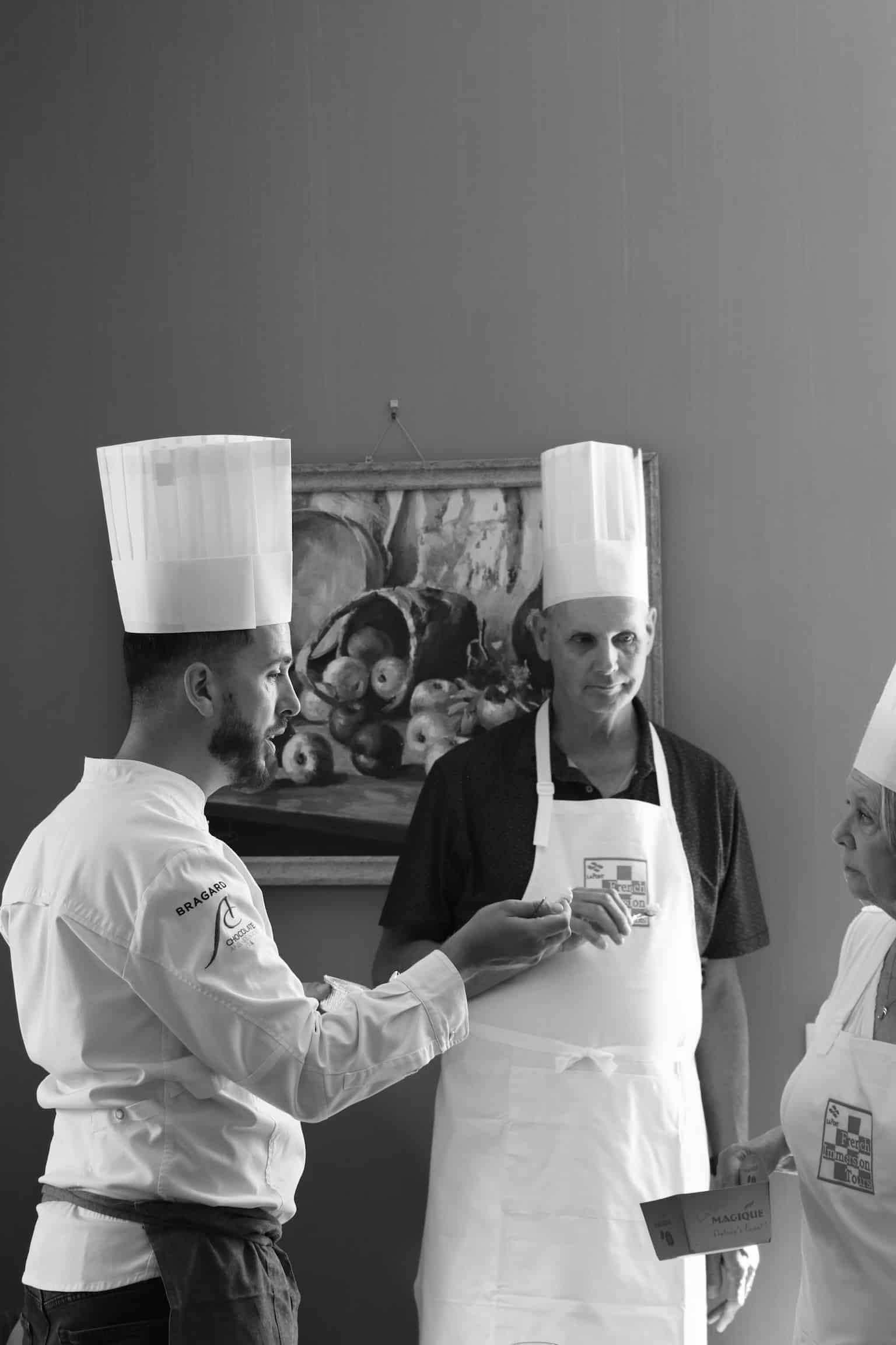 Chef Bragard guidant des élèves en toque lors d'un cours de cuisine French Immersion.