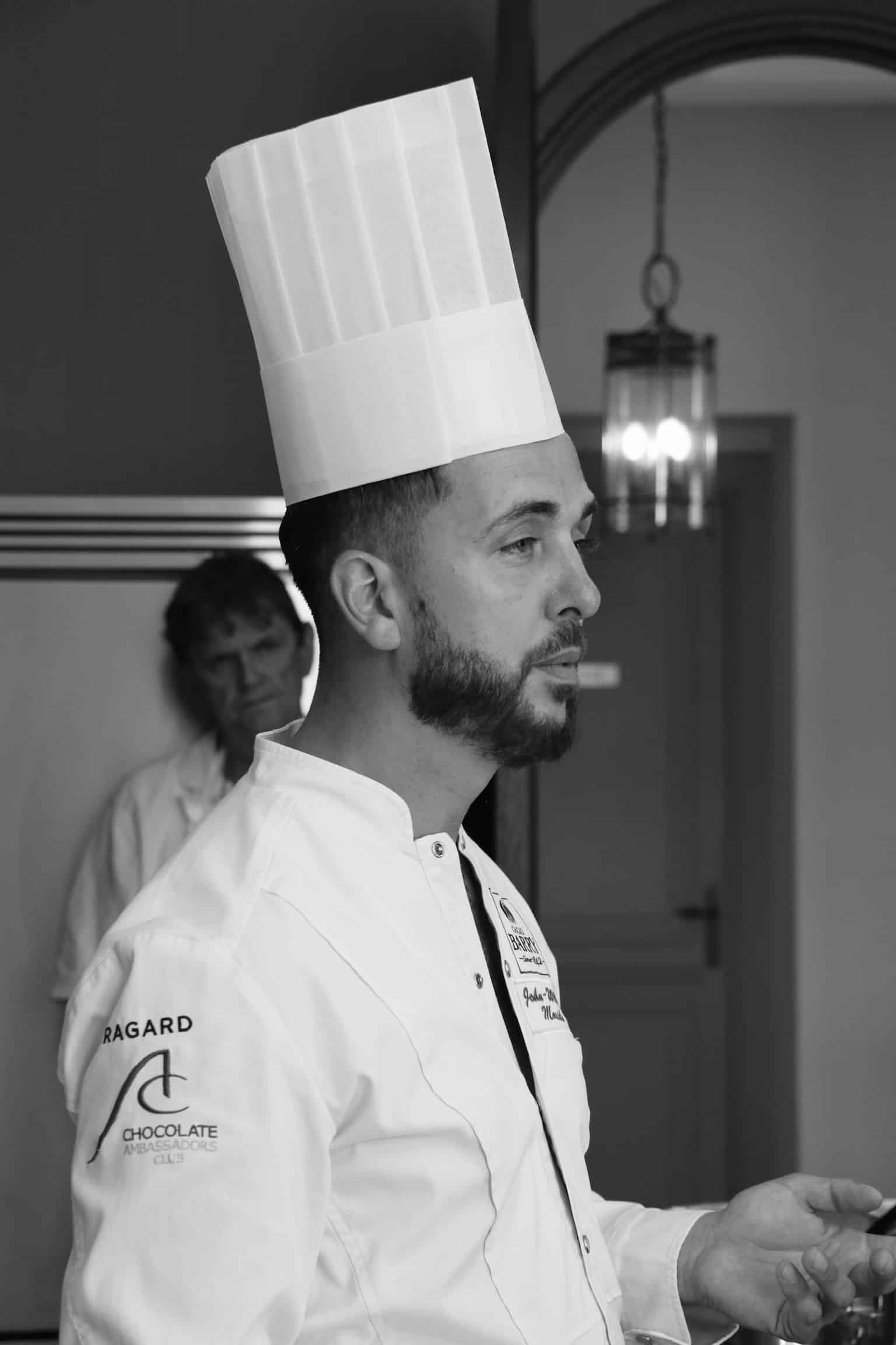 Chef barbu en toque et veste Ragard, membre du Chocolate Ambassadors Club, s'exprimant.