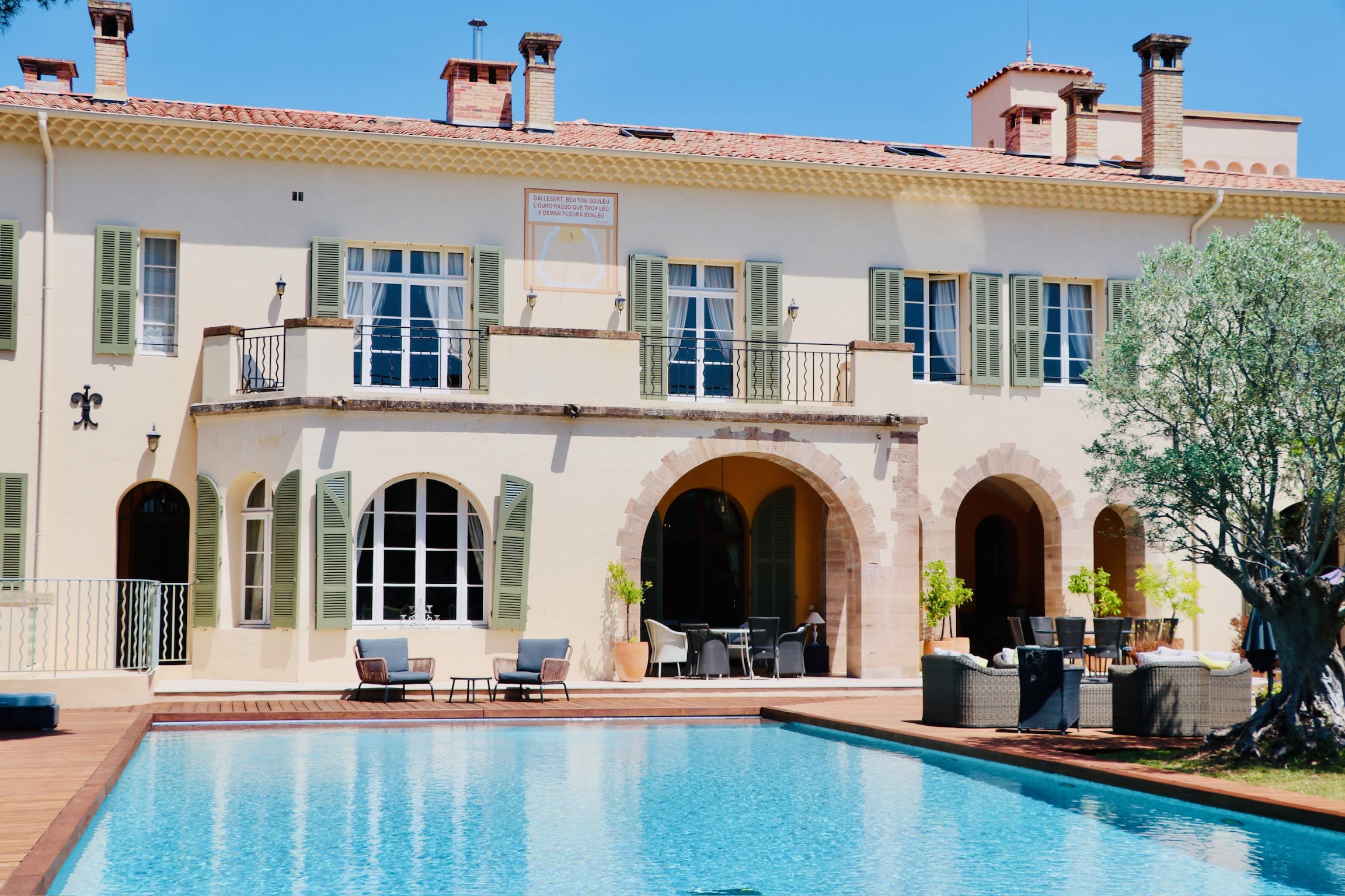 Villa avec piscine, volets verts et cadran solaire 'Gaï Lésert, beu ton souléu'. Cadre luxueux et calme.